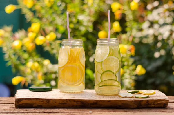 Ahşap bir masada, çeşitli arka planlarda taze meyve suları.