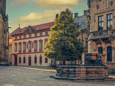 Prag 'ın tarihi mimarisinin manzarası, karakteristik kırmızı kiremitli çatıları olan antik binalardan oluşan bir panorama sergiliyor. Bu görüntü, Çek başkentinin iyi korunmuş medyası ile ünlü eşsiz cazibesini ve zamansız güzelliğini yansıtıyor.