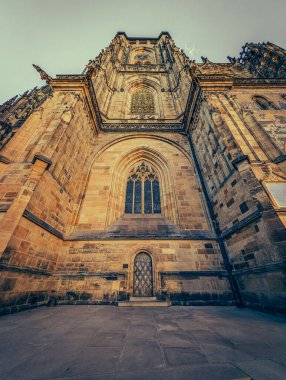 Prag 'ın tarihi mimarisinin manzarası, karakteristik kırmızı kiremitli çatıları olan antik binalardan oluşan bir panorama sergiliyor. Bu görüntü, Çek başkentinin iyi korunmuş medyası ile ünlü eşsiz cazibesini ve zamansız güzelliğini yansıtıyor.