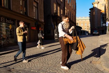 Stockholm, İsveç - 12 Mart 2016: Stockholm'de karşıdan karşıya geçen kimliği belirsiz erkekler.