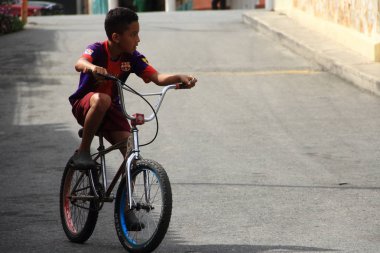 Gonzalez, Venezuela - 6 Haziran 2017: Gonzalez köyünde sokakta bisiklete binen genç çocuk.