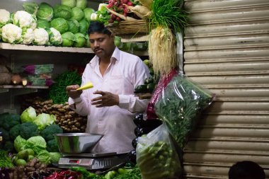 Mumbai, Hindistan - 15 Şubat 2019: Crawford pazarındaki bir sebze dükkanında yerel esnaf.