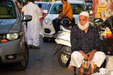 Mumbai, Hindistan - 22 Mart 2019: Meçhul yaşlı Müslüman adam Mumbai 'de, Hill Road' da küçük bir sandalyede oturuyor..