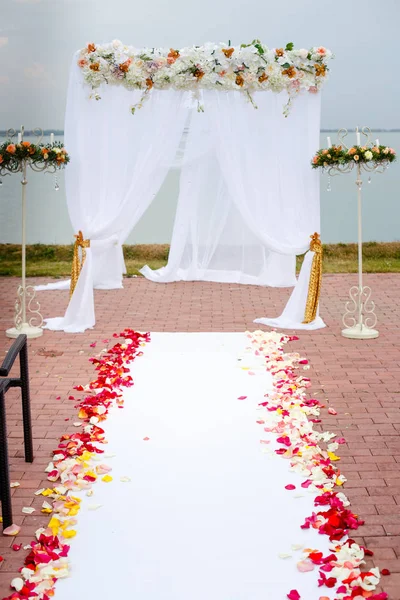 Cérémonie de mariage Arc décoré avec des arrangements floraux sur la pelouse verte et l'eau avant — Photo