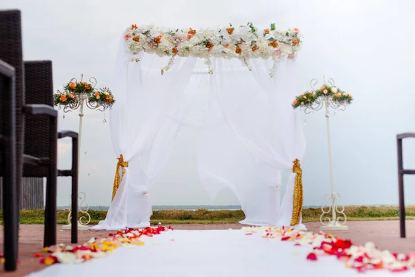 Cérémonie de mariage Arc décoré avec des arrangements floraux sur la pelouse verte et l'eau avant — Photo