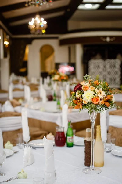 Décor de mariage sur les tables en restaraunt, un bouquet de fleurs avec un vase en verre — Photo