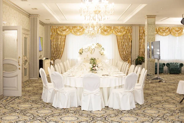 Золотые свадебные украшения в желтой комнате ресторана, имена за столом, банкет — стоковое фото