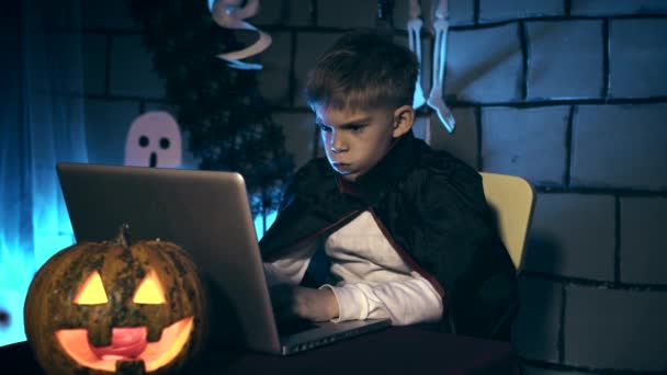 在万圣节的吸血鬼服装的小男孩显示他的可怕的脸和牙齿的人在互联网上 — 图库视频影像