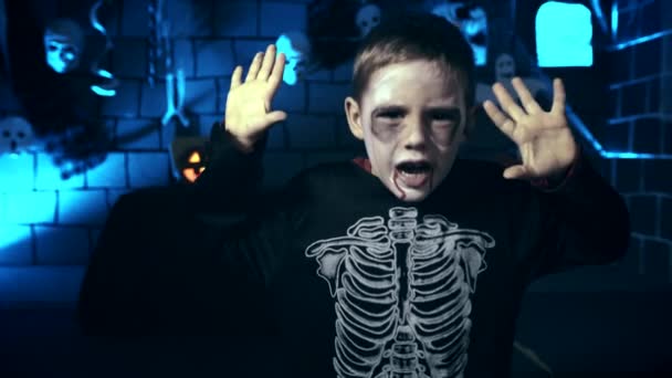 頭蓋骨化粧怖がらせるために指を使用してハロウィーンの怖い少年 — ストック動画