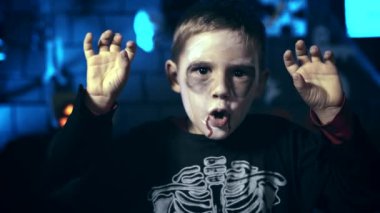 Kafatası makyaj korkutmak için parmaklarını kullanarak Cadılar Bayramı için korkunç küçük çocuk