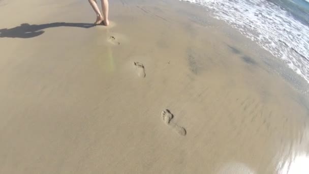 男は砂浜を歩き 砂の中に痕跡を残します — ストック動画