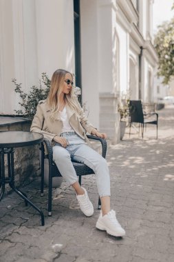 Sokakta poz veren şık kadın, güneş gözlüğü takıyor. Moda 