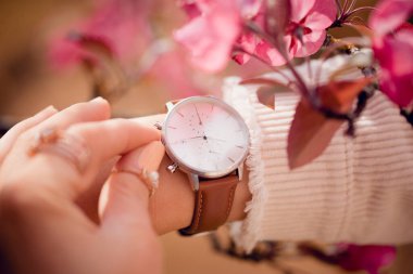 Çiçekli bir kadının üzerinde şık beyaz bir saat