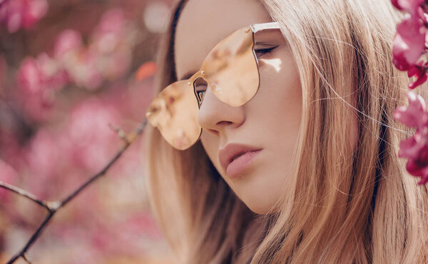 Beautiful young blonde woman in sunglasses in outdoor.