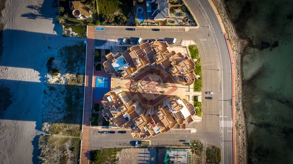 Overhead view of building complex next to ocean