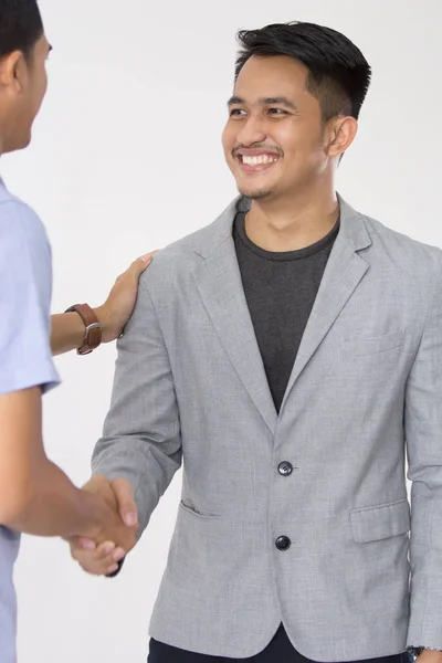 つの若いビジネスマンが揺れとお互いに笑みを浮かべて手との契約を — ストック写真