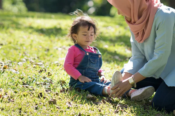 Moeder zetten schoenen met haar dochter — Stockfoto