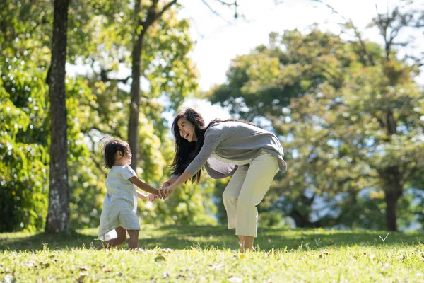 公園で遊んでいる母親と娘は — ストック写真