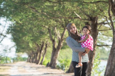 Anne ve kızın ağaçları arasında yürümek