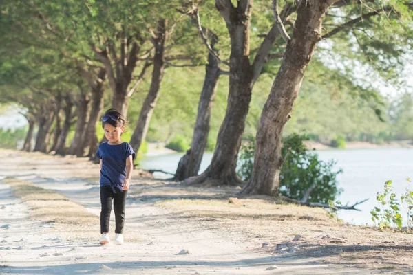 Kid walking alone between trees — Stock Photo, Image