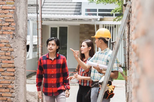 Byggnadsarbetare med husägaren — Stockfoto