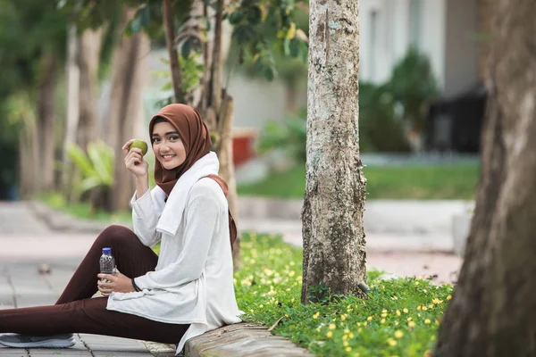 Deporte femenino musulmán comiendo una manzana — Foto de Stock