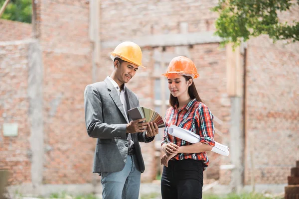 Arquitecto femenino y masculino recogiendo el color de pintura — Foto de Stock