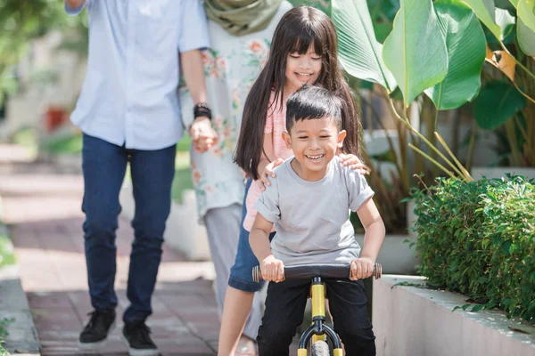 Garoto se divertindo com a irmã andando de bicicleta — Fotografia de Stock