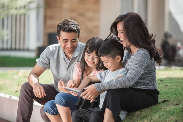 Jovem família moderna usando tablet — Fotografia de Stock