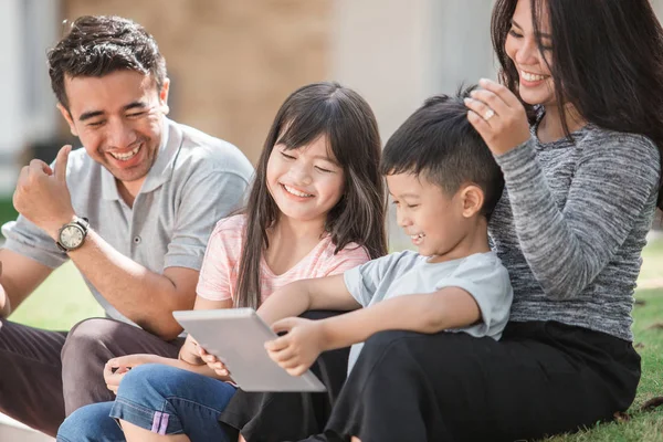 Family in front of their house using tablet — Stock Photo, Image