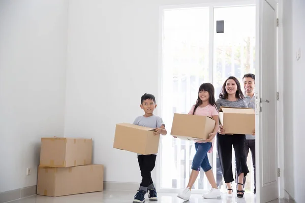 Padres e hijos con caja de cartón. mudanza a nueva casa — Foto de Stock