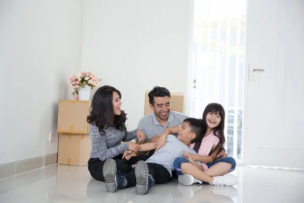 Parent and kids with cardboard box. moving to new house — Stock Photo, Image