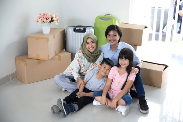 Eltern und Kinder mit Karton. Umzug in neues Haus — Stockfoto