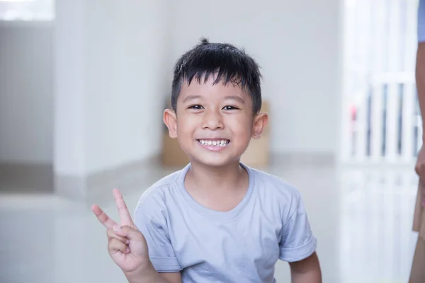 Gelukkig kind lacht om de camera in zijn huis — Stockfoto