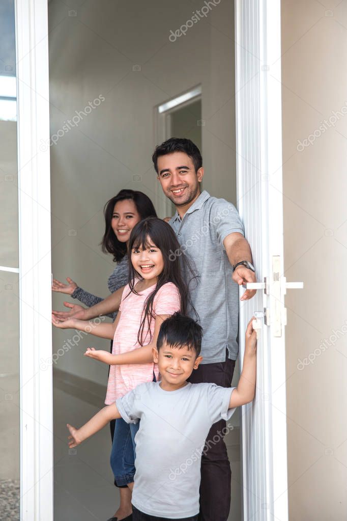 happy family with kids open their house door 
