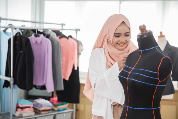 woman tailor working with mannequin