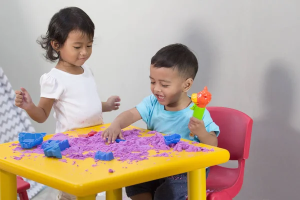 Dos niños pequeños juegan a la arena en casa —  Fotos de Stock