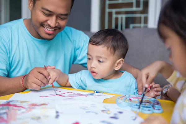 Niño pintando acuarela con papá —  Fotos de Stock