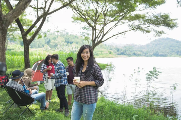 Wanita tersenyum ke kamera saat berkemah — Stok Foto