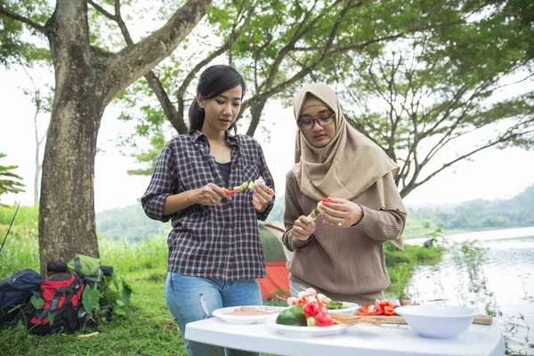 Preparing food with skewers during outing — Stock Photo, Image