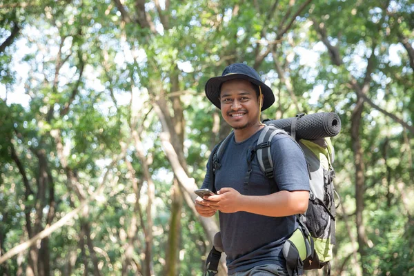 Hombre usando el teléfono móvil en el bosque — Foto de Stock