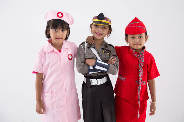 Three little girl in different profession uniform Stock Photo