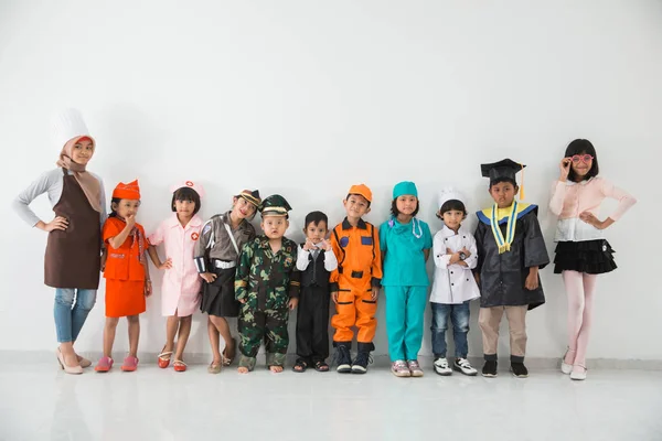 Farklı mesleklerden kostümler giymiş çocuk — Stok fotoğraf
