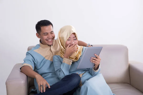 Casal muçulmano em um sofá com tablet — Fotografia de Stock