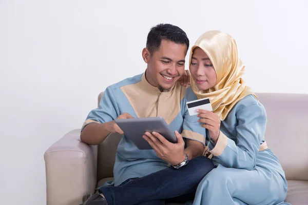 Casal muçulmano em um sofá com tablet — Fotografia de Stock