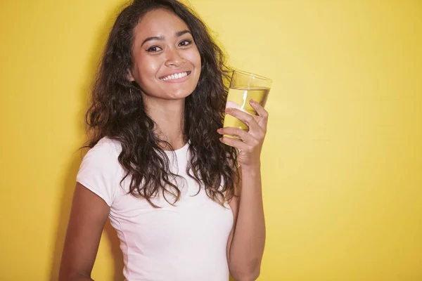 Asiatische Mädchen mit schönen Lächeln und hält ein Glas Wasser — Stockfoto