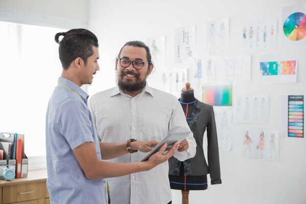 два партнера дизайнера с помощью планшетного ПК
