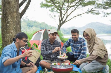 Arkadaşlar açık havada birlikte bir Barbekü yapma