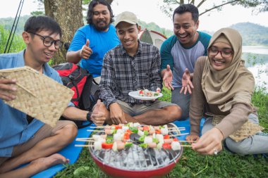 Arkadaşlar açık havada birlikte bir Barbekü yapma