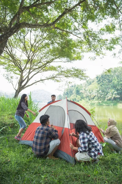 Tourist help each other prepare tent — Stock Photo, Image